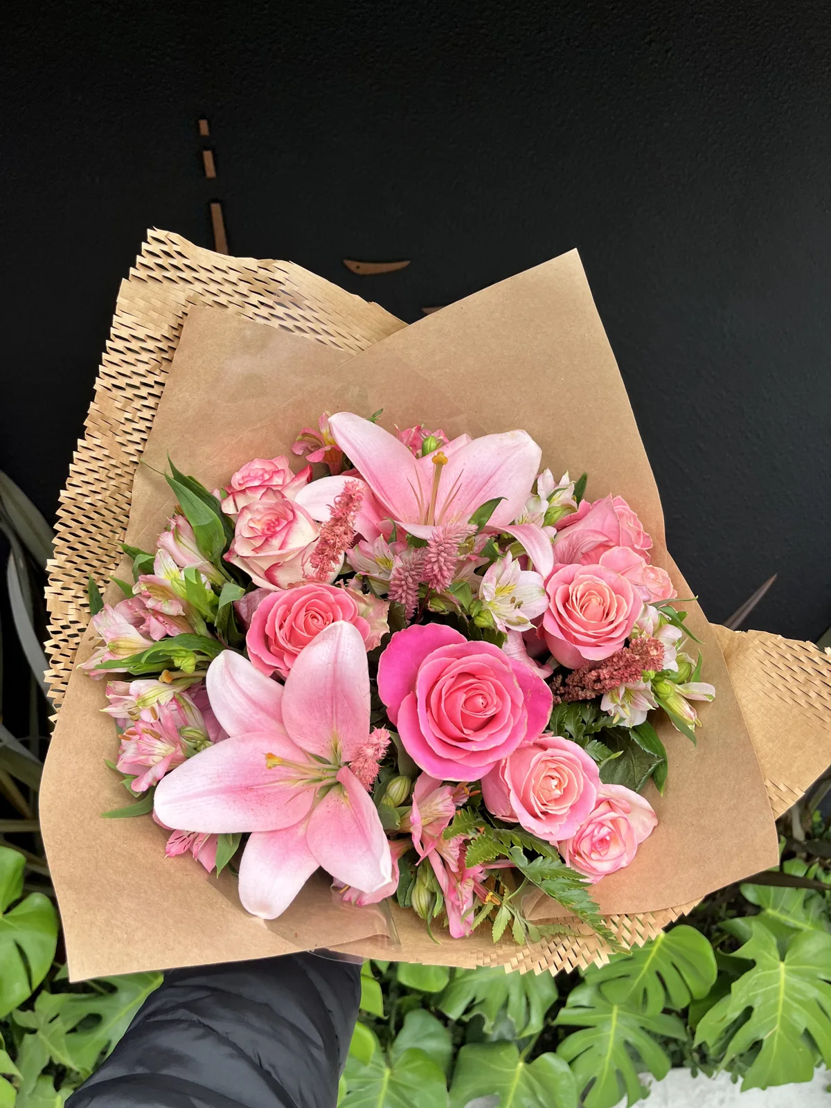 Buquê da BC Flores com rosas e lírios cor-de-rosa em embalagem kraft