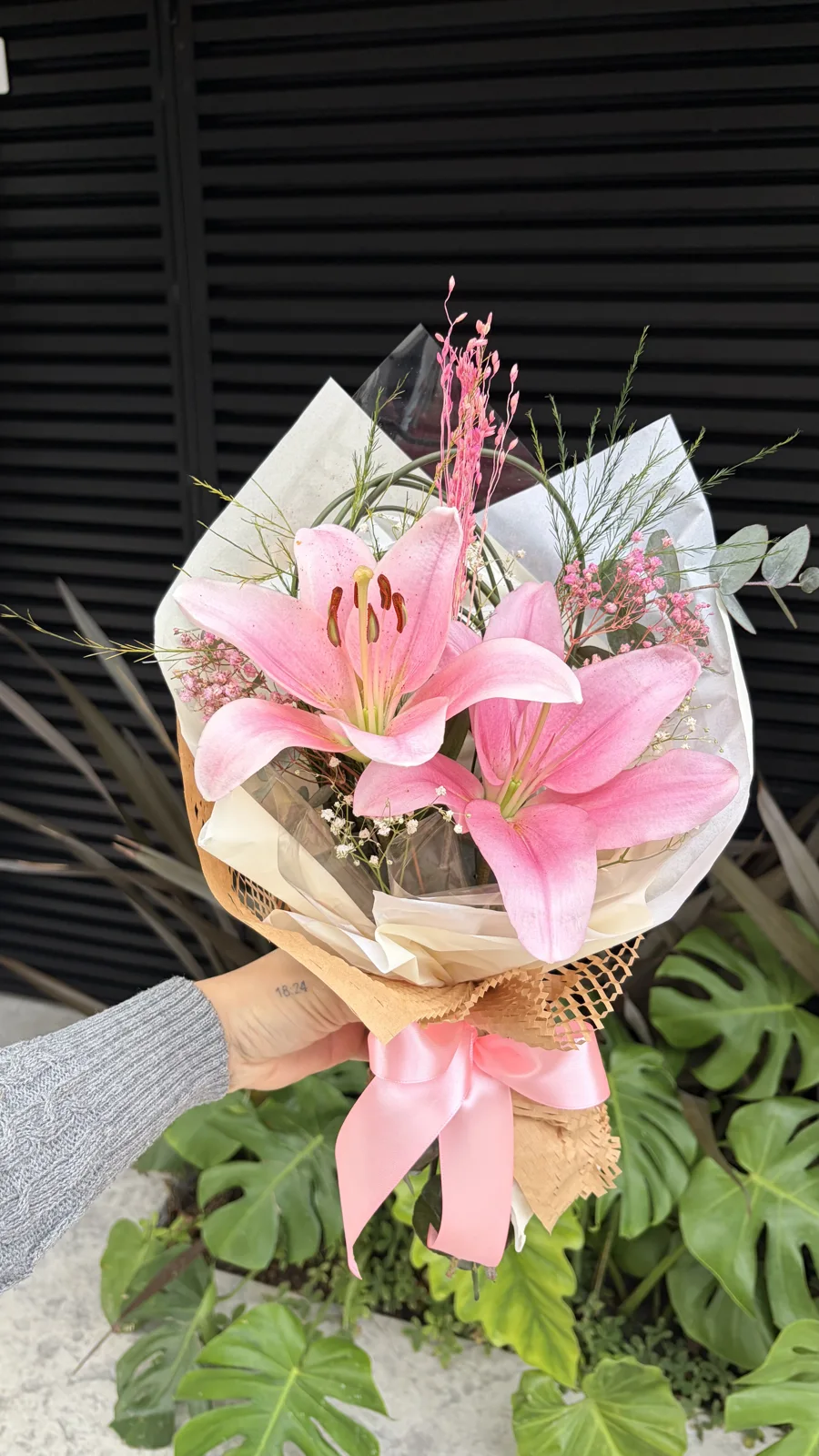 Buquê delicado de lírios cor-de-rosa com pequenas flores brancas